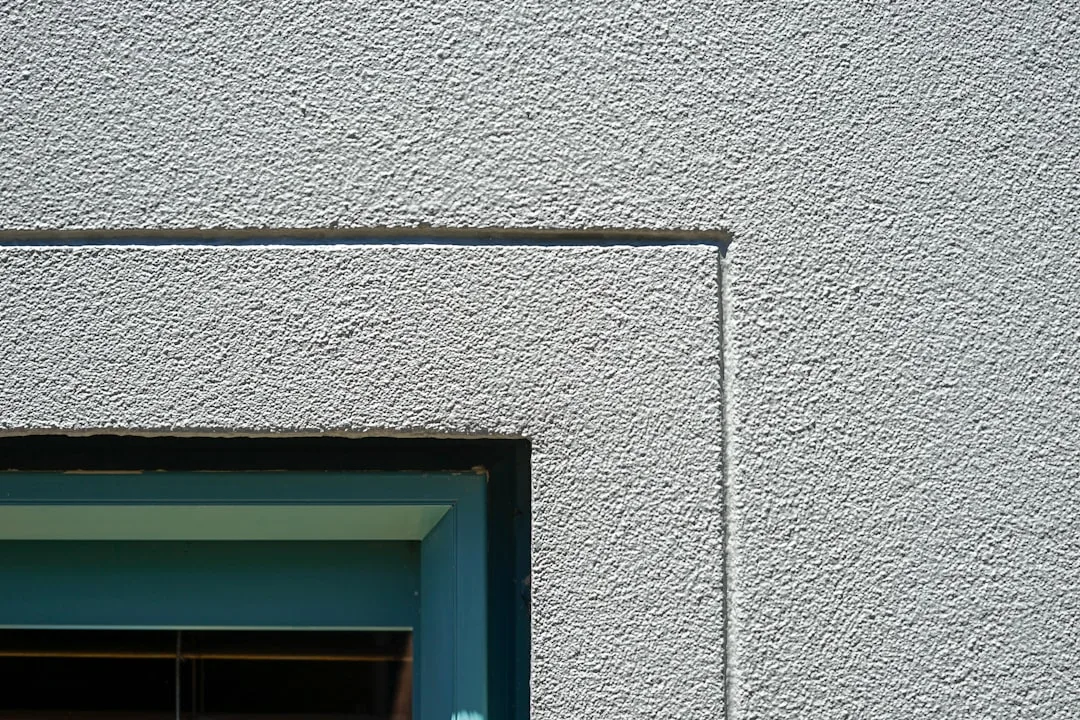 a cat sitting in a window sill of a building