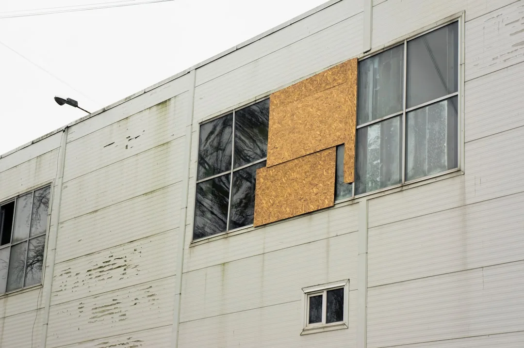 A large white building with windows and a bird sitting on the window sill
