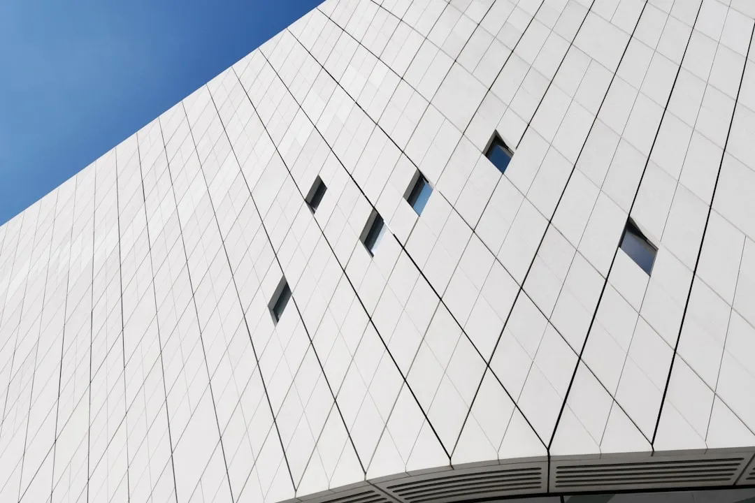 a white building with several windows and a sky background