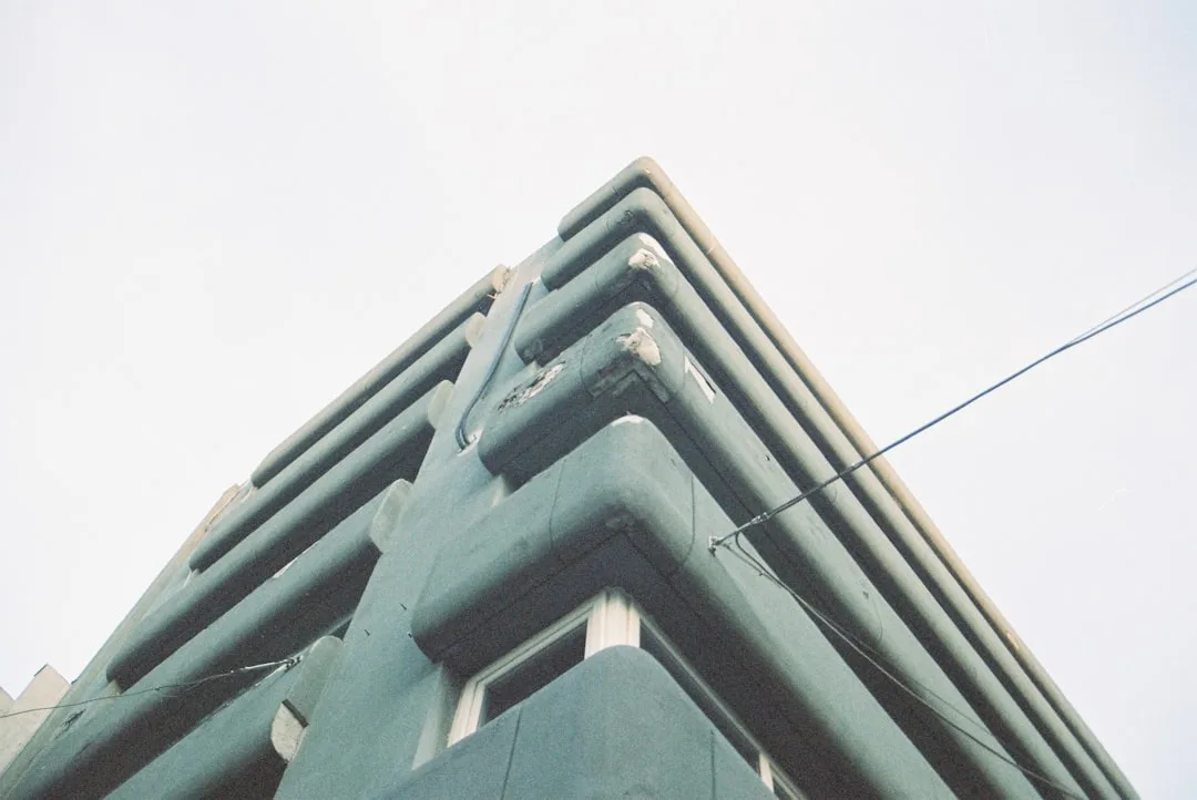 A teal building with layered horizontal lines