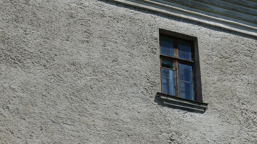 blue wooden window on gray concrete wall