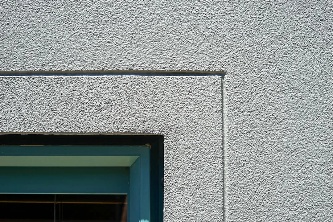 a cat sitting in a window sill of a building