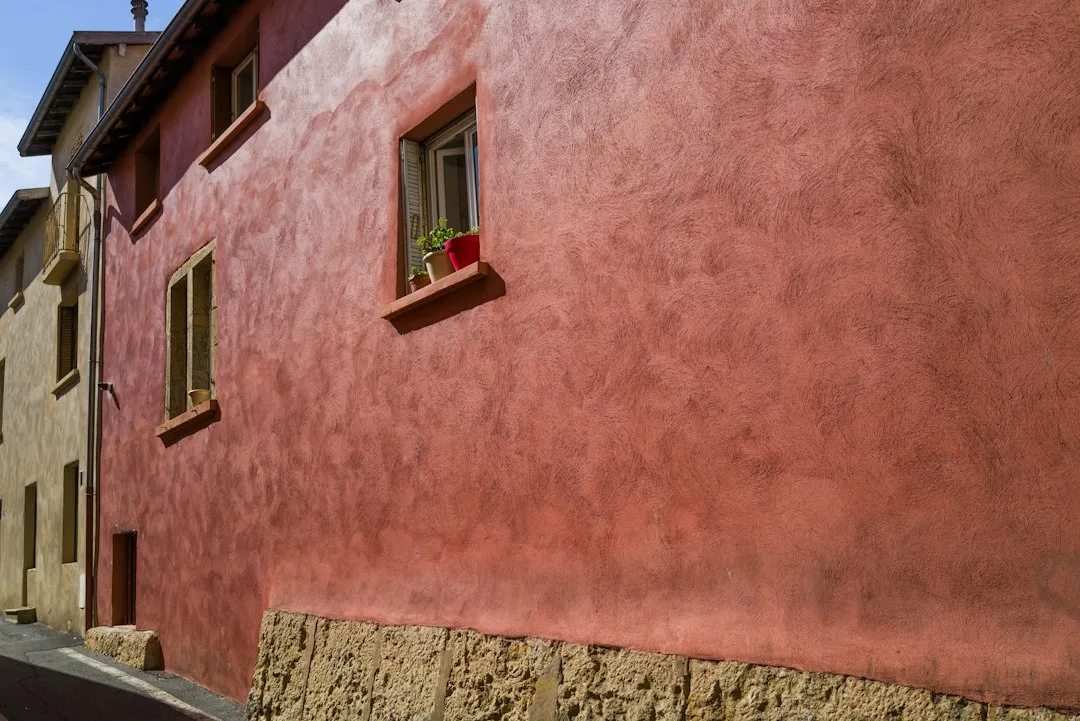 a red building with a window on the side of it